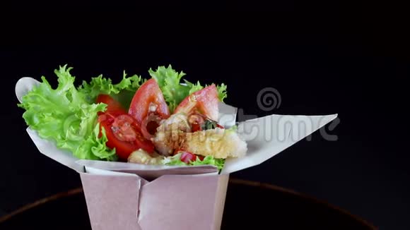 健康的饮食蔬菜沙拉和奶酪西红柿和黄瓜片平板特写在黑色背景上旋转视频的预览图