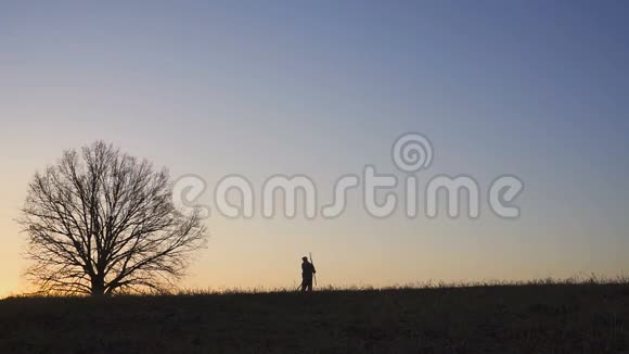一个满意的农民在田里跳舞田野里日落或日出的剪影视频的预览图