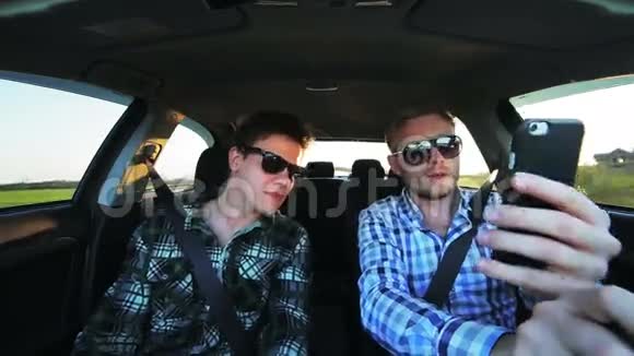 两个人开着车用电话微笑着视频的预览图
