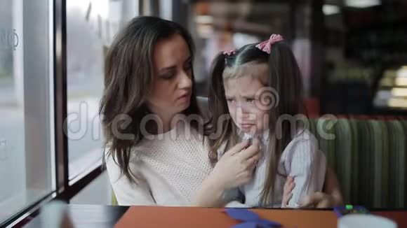 母亲平静地拥抱着一个哭泣的小女孩女儿的眼泪流在脸上视频的预览图