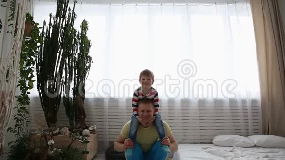 现代健康家庭爸爸和他的小儿子在家参加体育活动视频的预览图