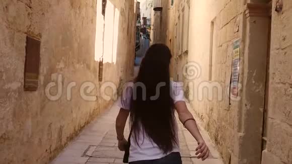 快乐的女孩在小街上奔跑视频的预览图
