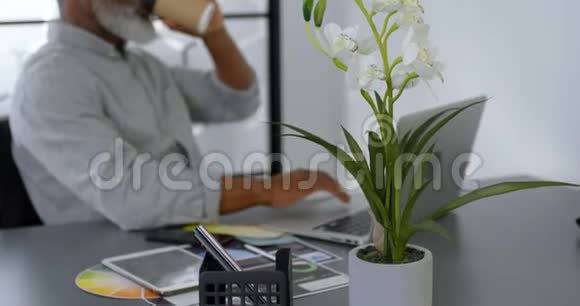 商务人员在办公桌4k上使用笔记本电脑时喝咖啡视频的预览图