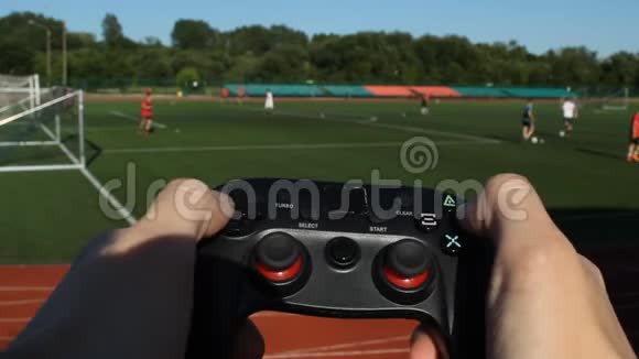 这名男子点击体育场背景上的游戏操纵杆和足球比赛的按钮特写视频的预览图