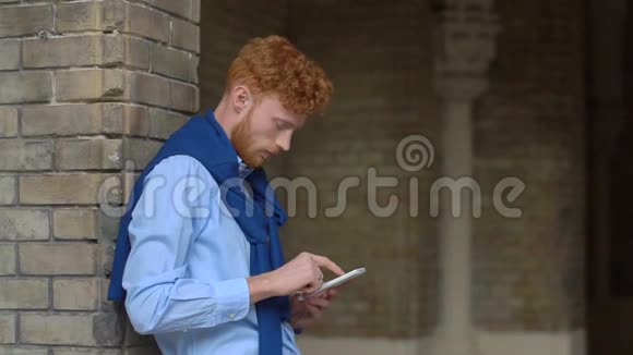 侧半幅红色姜发熊通过手机聊天浏览发短信的男子画像视频的预览图