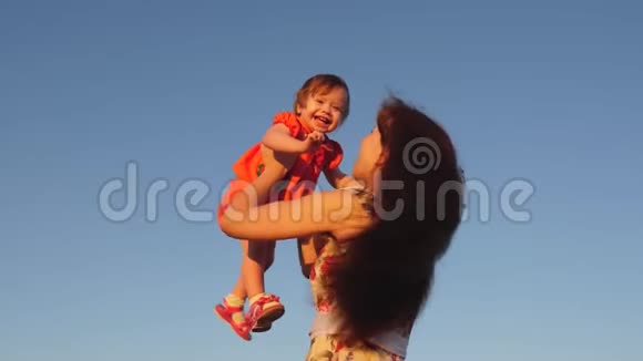 妈妈把女儿扔到天上母亲和一个小孩子在蓝天上玩耍幸福的家庭在玩耍视频的预览图