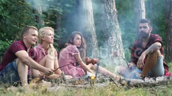 快乐的朋友在大自然中玩音乐享受篝火孩子们在森林里玩得很开心坐在里面的朋友视频的预览图