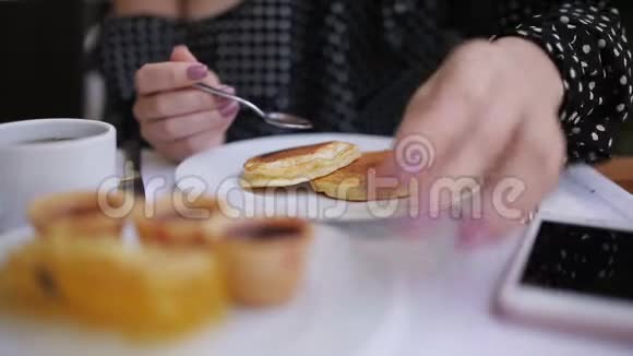在咖啡馆的桌子上放果酱煎饼的女人视频的预览图