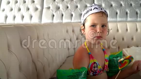 小女孩吃五颜六色的糖果在海里洗澡后视频的预览图