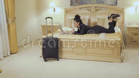 漂亮的商务女士在酒店房间里使用笔记本电脑视频的预览图