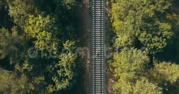 人在火车轨道上奔跑的无人机顶景图摆脱过去的问题追逐梦想和幸存的生命考验视频的预览图