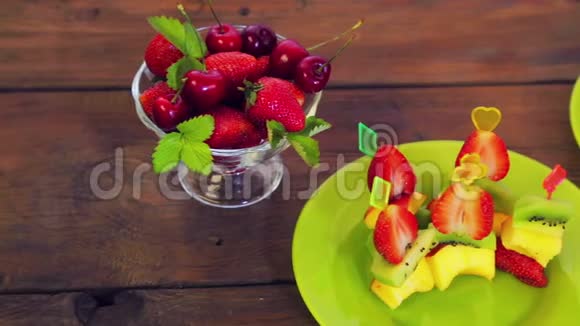 在一张白色的盘子上躺在一张深色的木桌上是草莓和樱桃特写视频的预览图