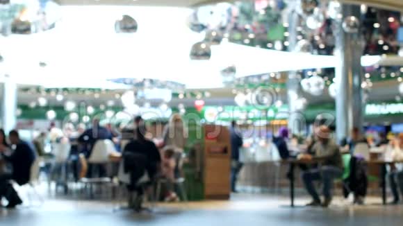 购物中心的咖啡厅人们在咖啡厅休息去购物现代购物中心模糊了视频的预览图