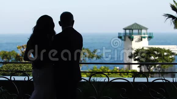 新郎和新娘拥抱大海的剪影视频的预览图