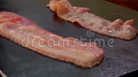 两条咸肉条在烤架上嘶嘶作响煎炸视频的预览图