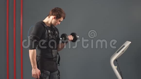 穿着肌肉电刺激服的人站在哑铃上视频的预览图