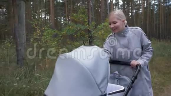 一位年轻漂亮的母亲带着婴儿车去公园和婴儿交流视频的预览图