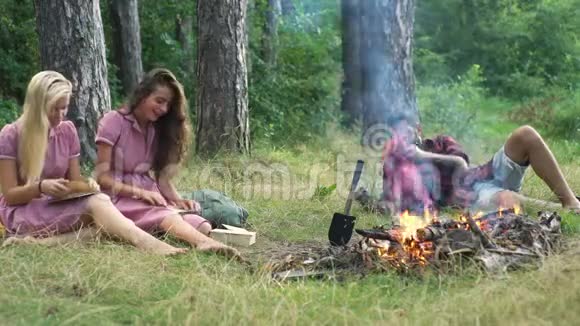 快乐的朋友在大自然中玩音乐享受篝火孩子们在森林里玩得很开心坐在里面的朋友视频的预览图