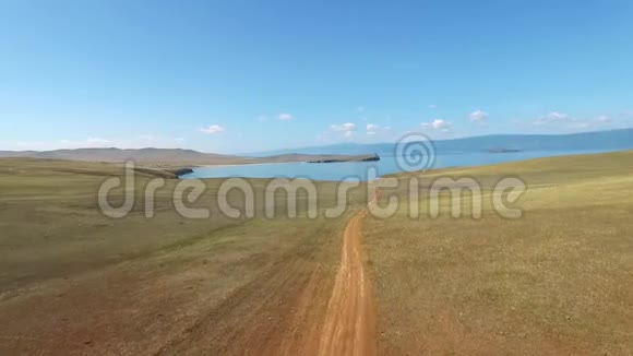 阳光明媚的一天奥克洪贝加尔湖通往蓝色海岸的土路的鸟瞰图视频的预览图
