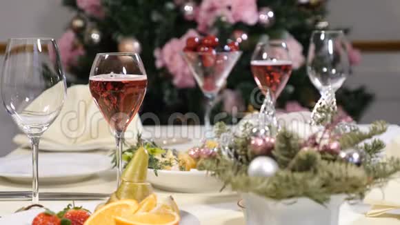 餐厅概念新年和圣诞大餐桌香槟泡在玻璃里切片水果盘奶酪视频的预览图