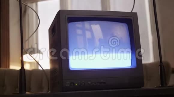 黑色复古电视机在沙发和灯的背景上打开显示视频的预览图