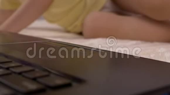 一个小孩按下笔记本电脑键盘上的按钮特写婴儿和电脑教育视频的预览图