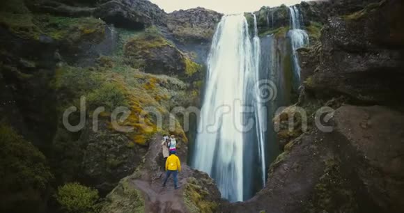 鸟瞰游客群欣赏冰岛的Gljufrabui瀑布美景朋友们徒步旅行后很开心视频的预览图