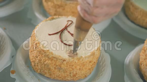 用奶油装饰纸杯蛋糕女人手在美味的蛋糕上放黄油霜视频的预览图