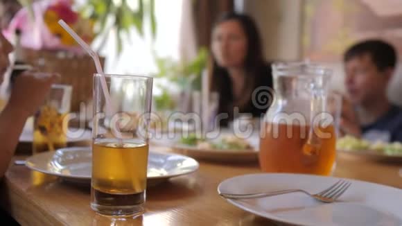 人们一家人在一家咖啡馆里吃晚餐喝果汁慢动作视频鸡胸肉沙拉大白菜视频的预览图