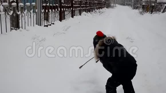 一个可爱的小男孩在冬天白雪覆盖的森林里扔雪在雪地里扔树好好享受冬天吧玩雪球视频的预览图