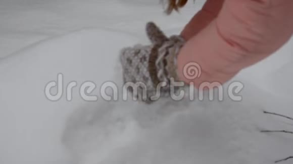 穿着米色手套的女孩成了一团雪摇雪寒假圣诞节和人们的概念关闭视频的预览图