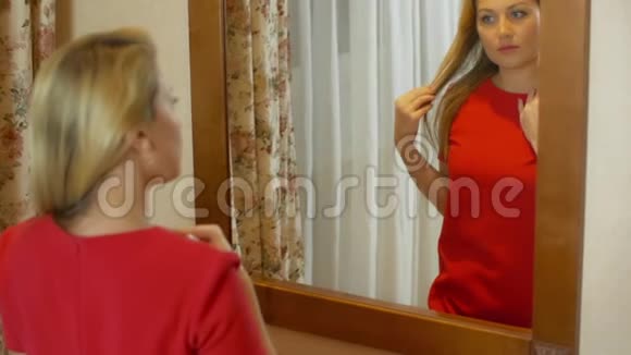 美丽的女人穿着红色的照镜子视频的预览图