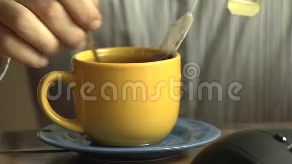 男人拿起小勺子开始在一杯热红茶里搅拌糖视频的预览图