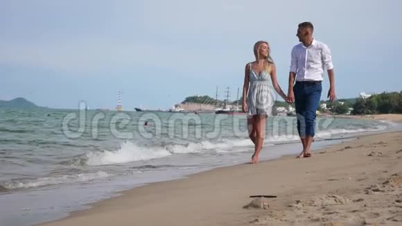 年轻的幸福夫妇在海滩上微笑着拥抱在一起浪漫的概念高清1920x1080视频的预览图