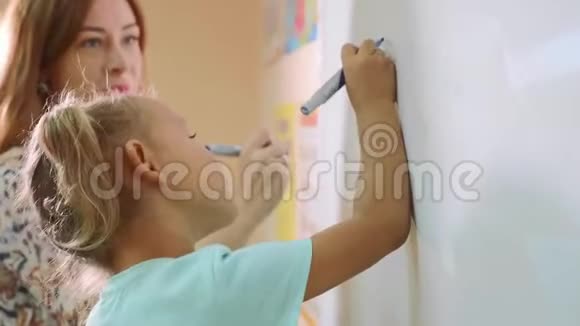 教室里老师在黑板上写字的小可爱女孩视频的预览图