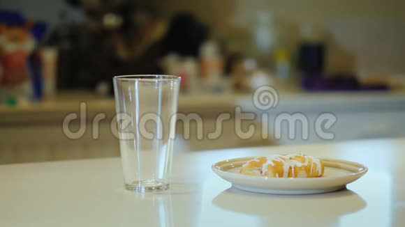 一个面目全非的女人把橙汁倒进杯子里喝健康食品和清淡早餐视频的预览图