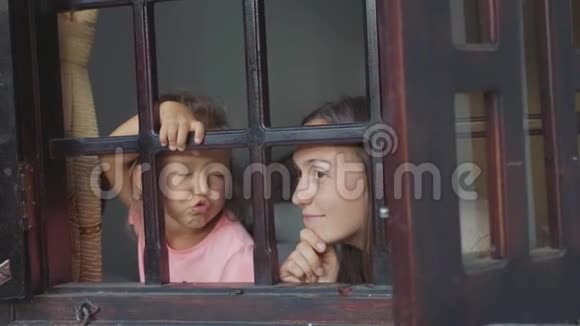 妈妈和小女儿正带着无聊的情绪望着窗外视频的预览图