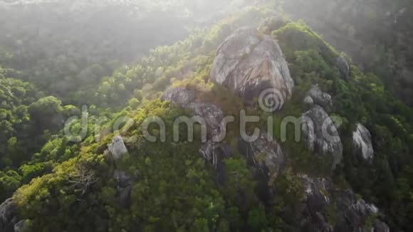 热带岛屿的丛林和山脉科岛火山岩地形上绿色丛林和巨大巨石的无人视野视频的预览图