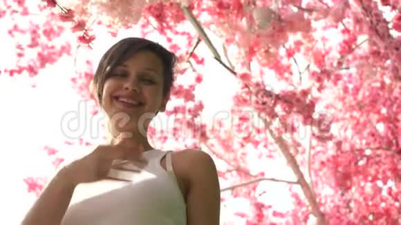 樱花背景上美丽的女孩视频的预览图