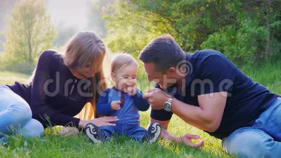 一个带着孩子的小家庭正在公园里休息玩你的小男孩一岁视频的预览图