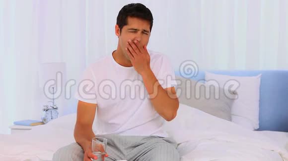 疲倦的人在床上吃药视频的预览图