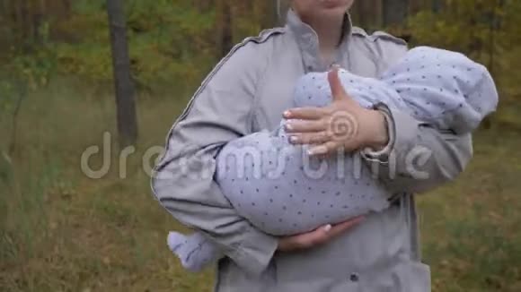 年轻可爱的妈妈在公园里抱着孩子视频的预览图