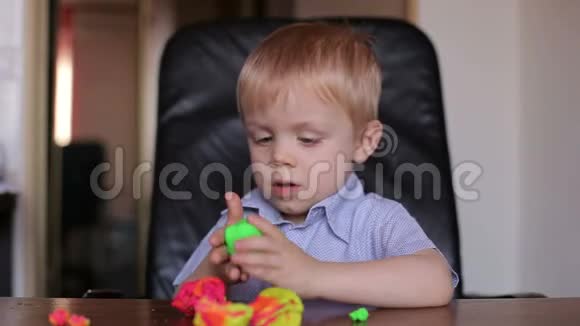 悲伤的小男孩玩五颜六色的塑料视频的预览图