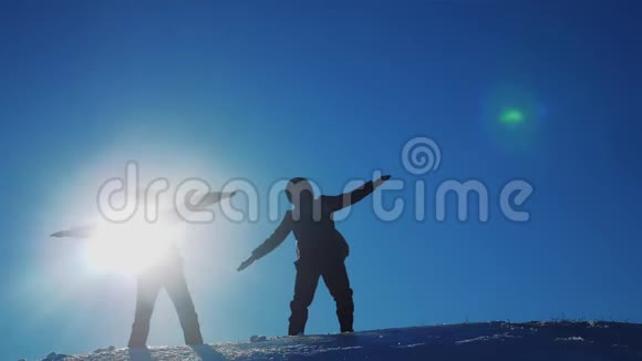 团队合作旅行两个人的登山者的剪影扮演两个人的登山者举起手模仿视频的预览图
