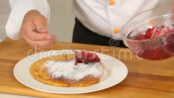 在白色的盘子里加入香草糖粉和浆果酱的新鲜烤薄饼视频的预览图
