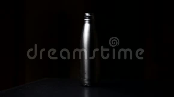 可重复使用的工作室图像钢热水瓶带帽在桌子上隔离在黑色背景上视频的预览图