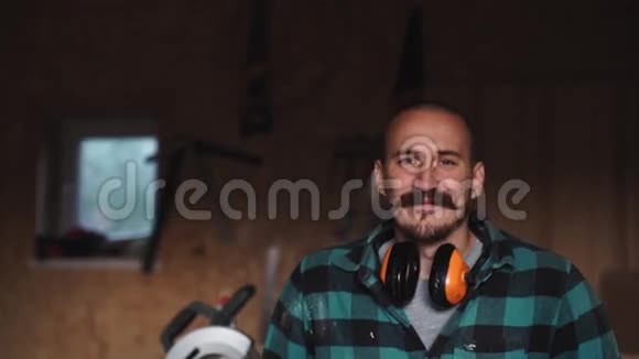 一位大胆的木匠的画像他的胡子留在工作服前的工作台工具上视频的预览图