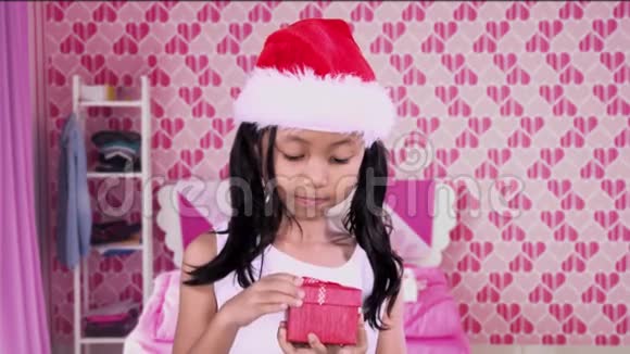可爱的女孩在卧室里打开圣诞礼物视频的预览图