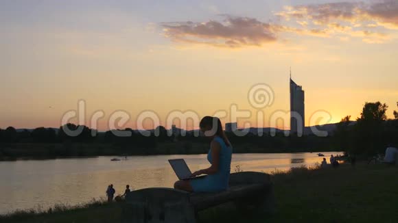 日落后的天空和带手提电脑的女孩视频的预览图