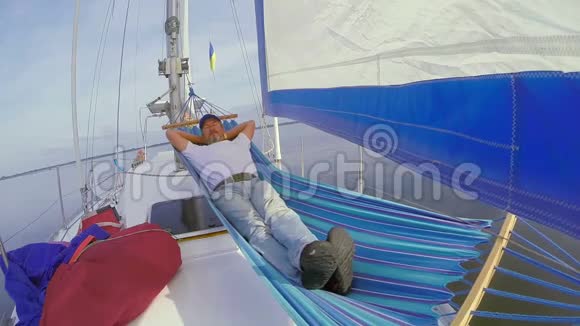 在游艇吊床上睡觉的老人度假休息视频的预览图